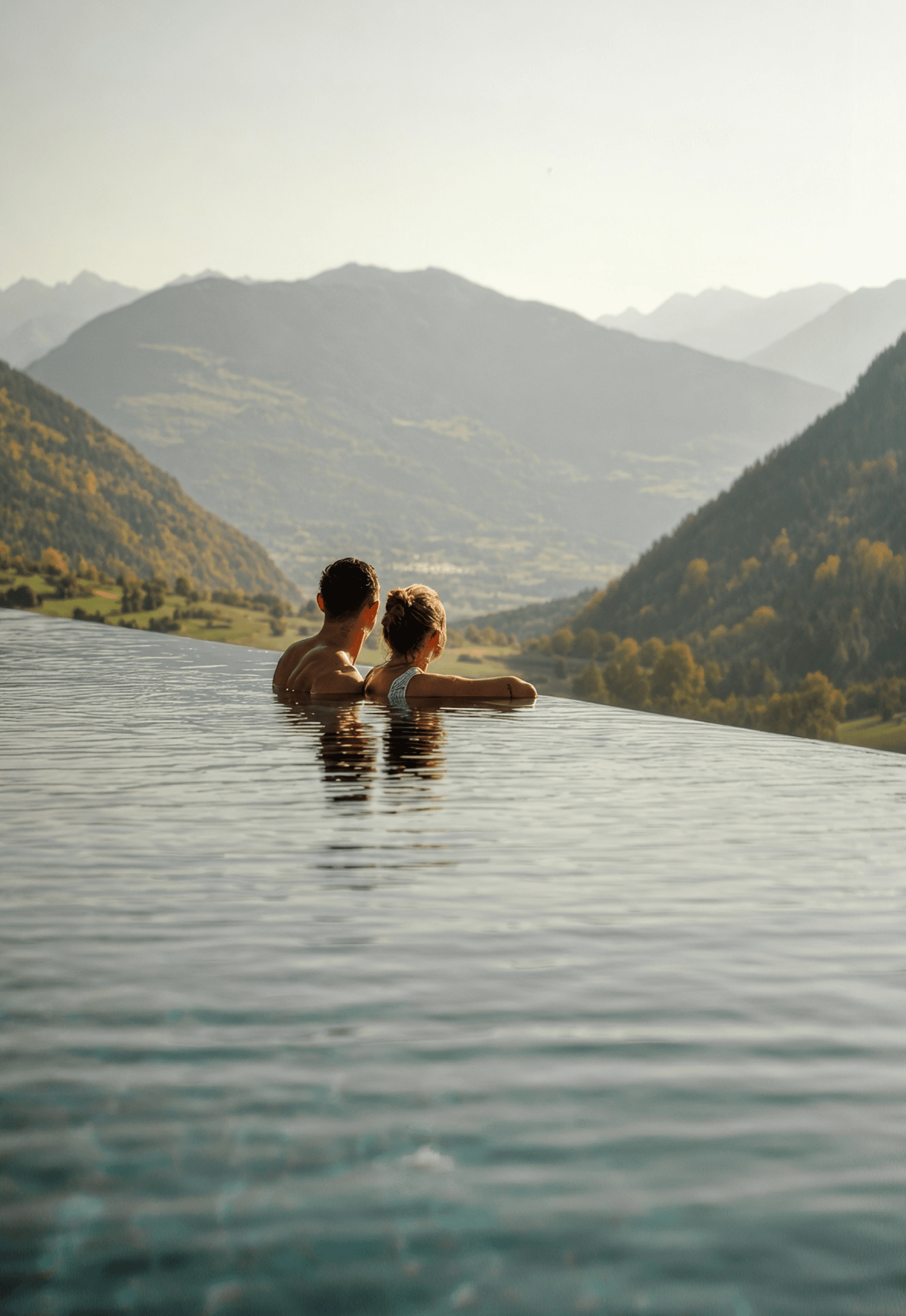 Paar im Infinity-Pool mit Blick ins Tal